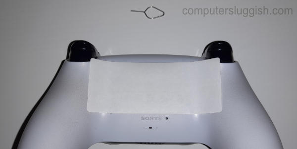 PlayStation 5 controller showing small pin hole location.